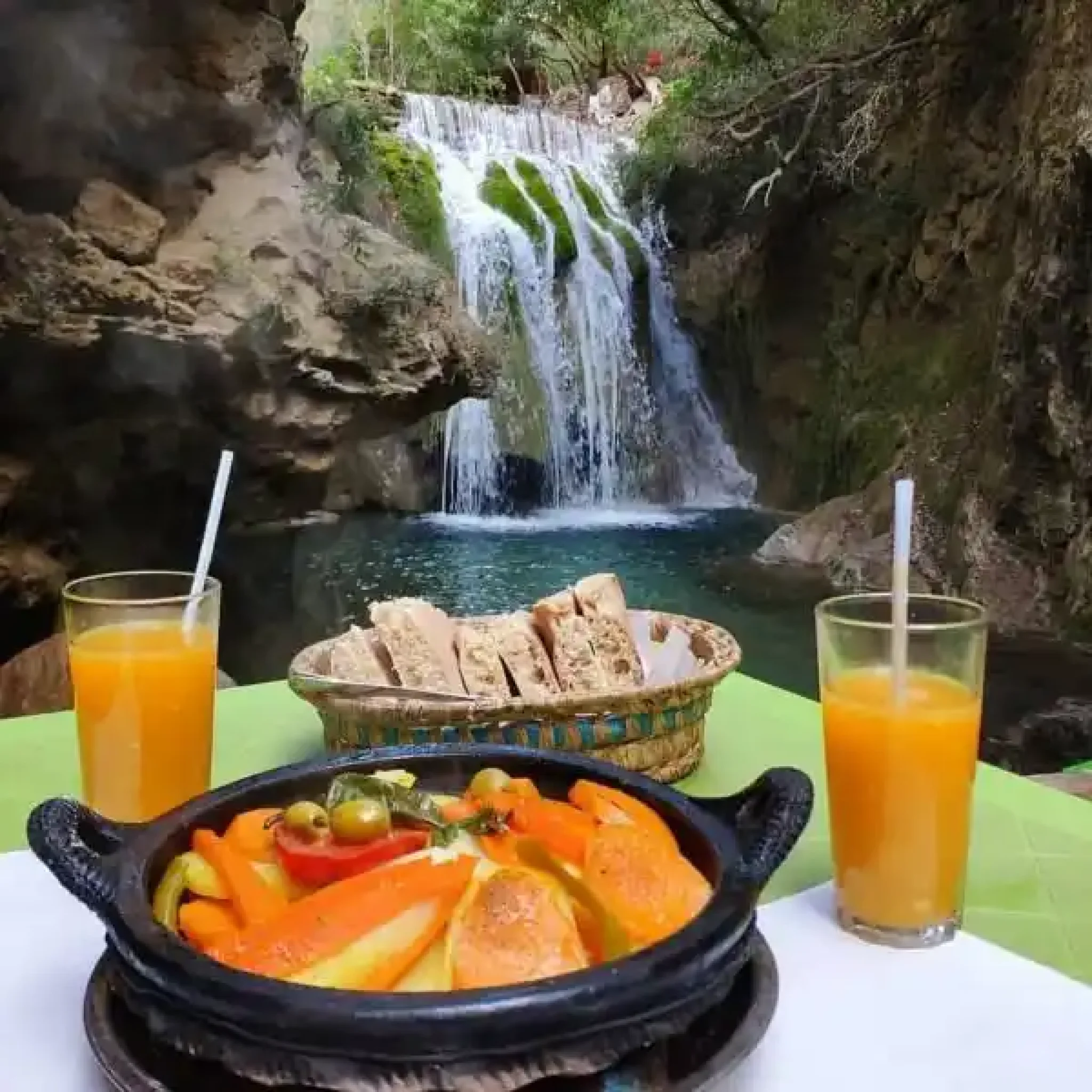 Image portraying the idyllic Day Trip Ourika Valley, with its lush landscapes, traditional Berber houses nestled among the hills, and the crystal-clear Ourika River flowing gracefully,