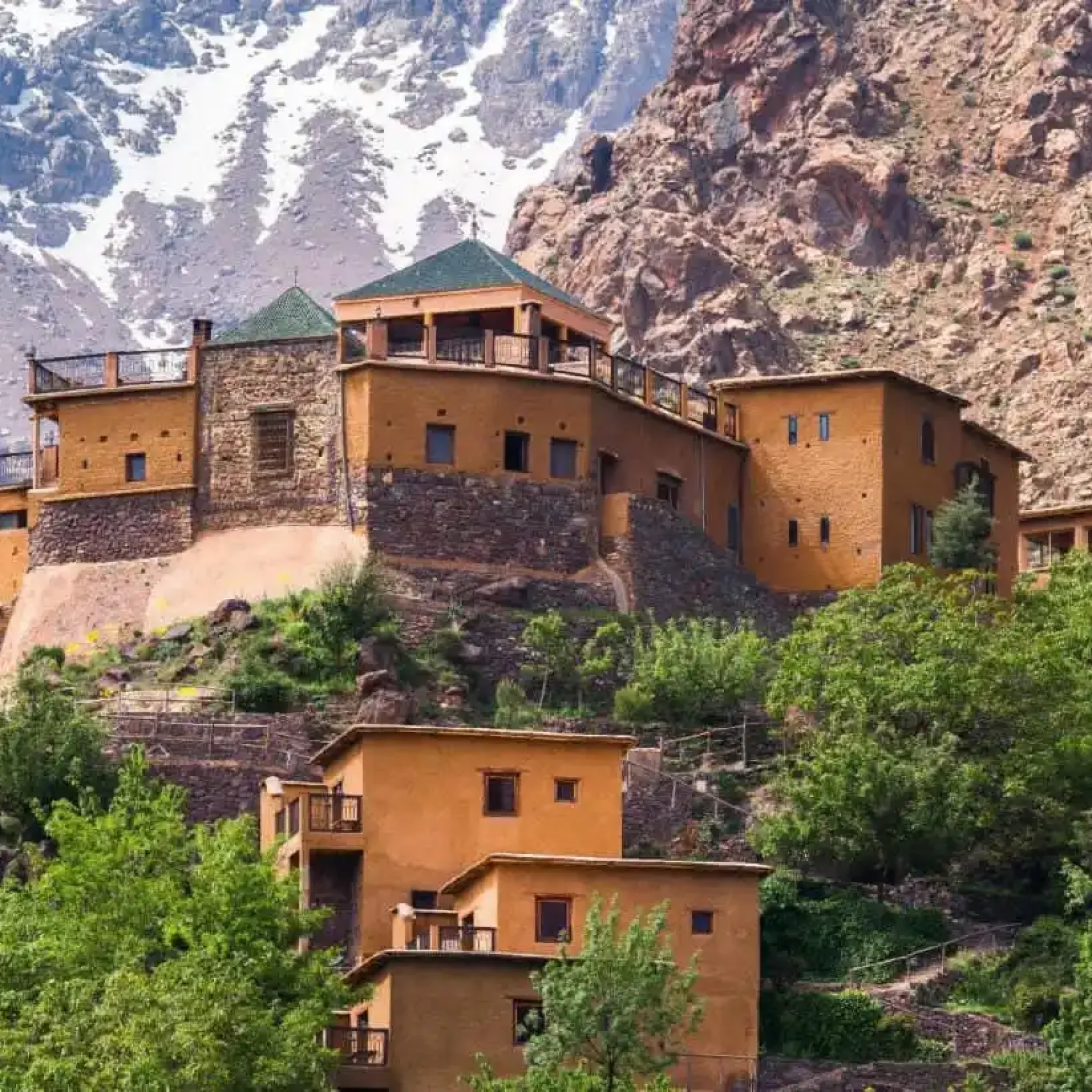 Image capturing the essence of the ultimate destination for an Imlil Day Trip: a picturesque view of lush valleys and rugged peaks of the High Atlas Mountains