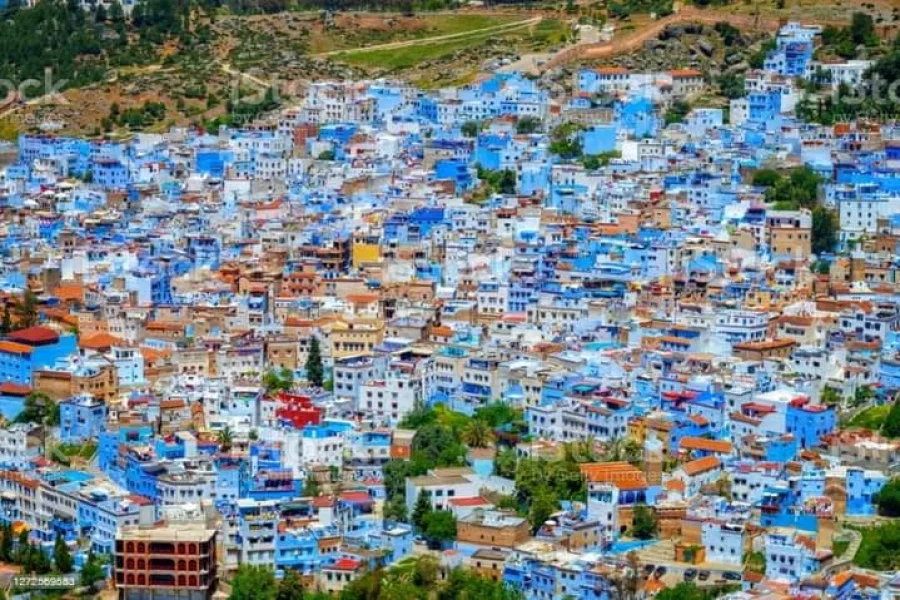 Group of travelers exploring the charming white-washed streets of Tangier on a 10 day Tour tangier excursions, enjoying the rich culture and vibrant colors of Morocco.