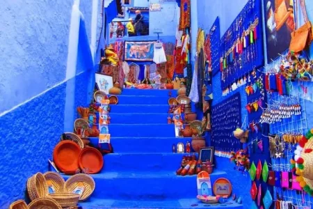 A panoramic view capturing the diversity of the Moroccan landscape, from the coastal city of Tangier, through the blue city of Chefchaouen, golden Sahara dunes, to the vibrant markets from Tangier to Marrakech