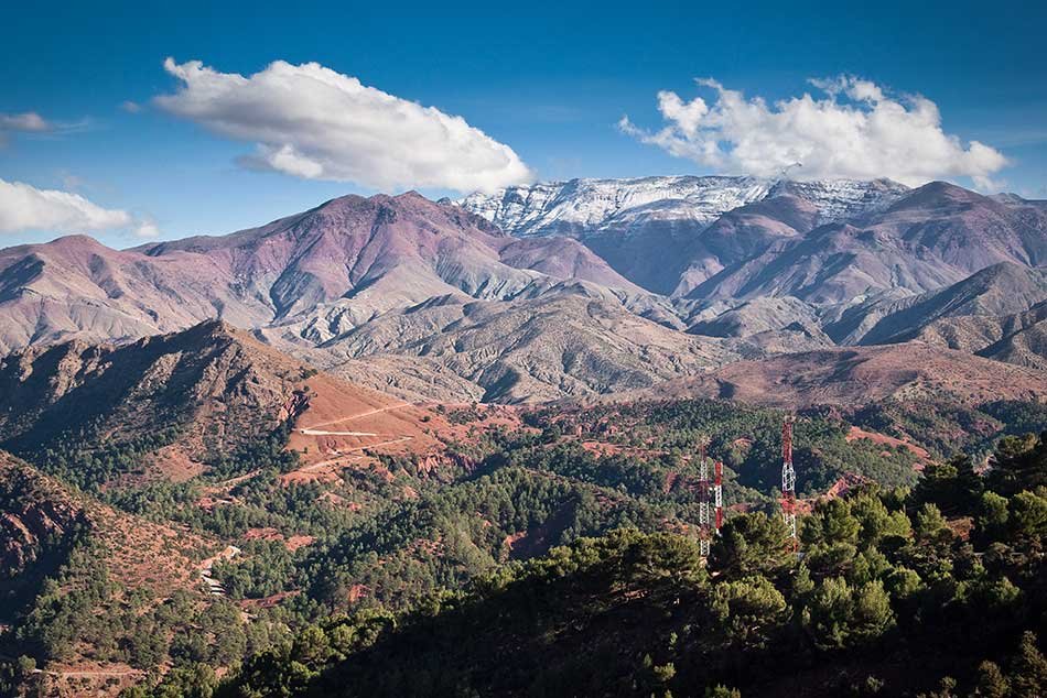 Tizi n'Tichka pass winding through the High Atlas Mountains in Morocco with snow-capped peaks in the distance.